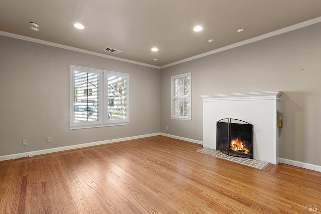 unfurnished living room featuring baseboards, visible vents, a fireplace, and light wood finished floors