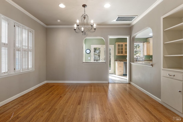 unfurnished dining area featuring light wood finished floors, plenty of natural light, visible vents, and ornamental molding