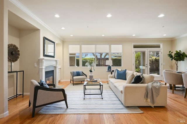 living room featuring light wood-type flooring, recessed lighting, and a glass covered fireplace