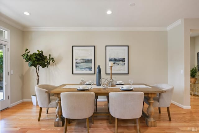 dining space with light wood-type flooring, baseboards, and crown molding