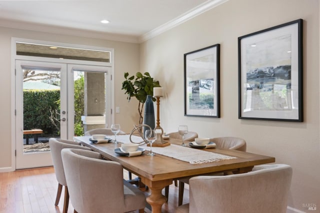 dining space featuring light wood finished floors, recessed lighting, ornamental molding, and french doors