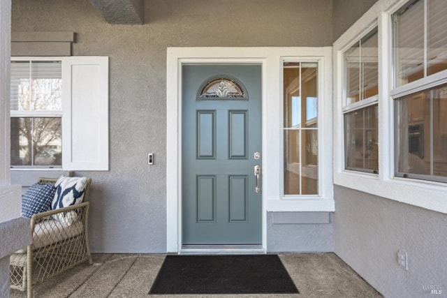 entrance to property featuring stucco siding