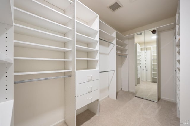 spacious closet featuring light colored carpet and visible vents