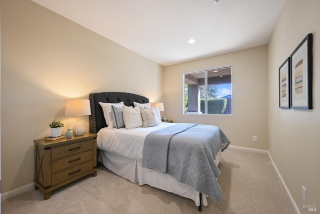 bedroom with light colored carpet and baseboards