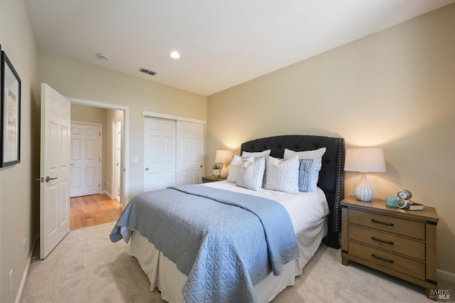 bedroom with recessed lighting, a closet, light colored carpet, visible vents, and baseboards