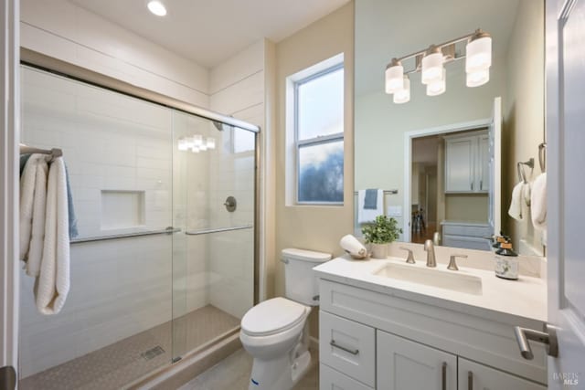 full bath featuring toilet, a stall shower, and vanity