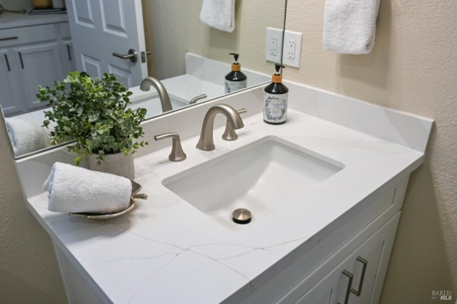 bathroom featuring a textured wall and vanity