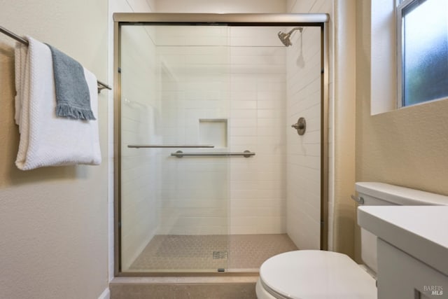 full bathroom with vanity, a shower stall, and toilet