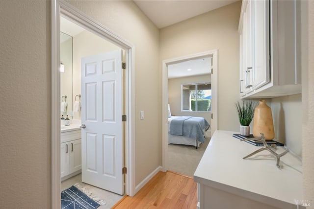 hallway featuring light wood-type flooring and baseboards