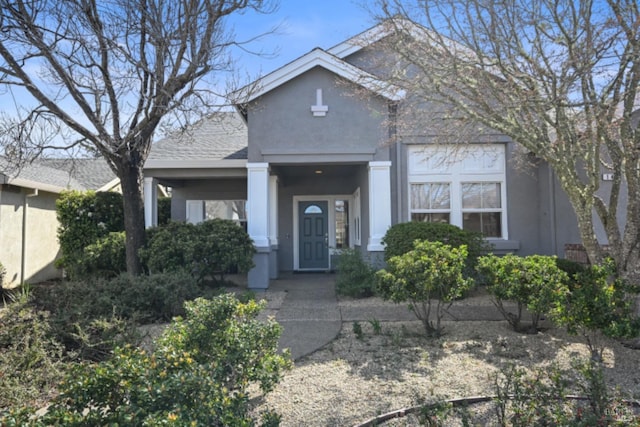 view of front of property featuring a shingled roof and stucco siding