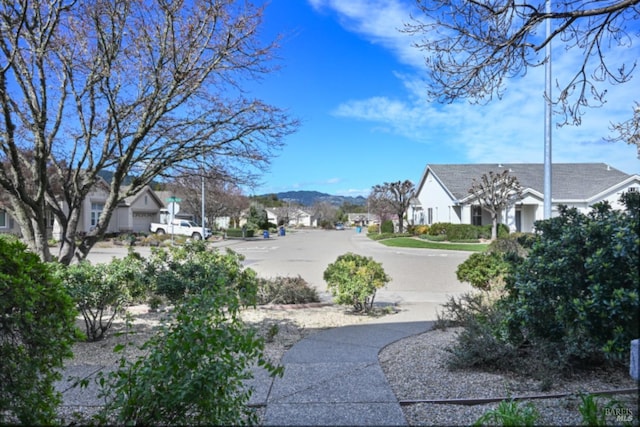 view of road featuring sidewalks, a residential view, and a mountain view