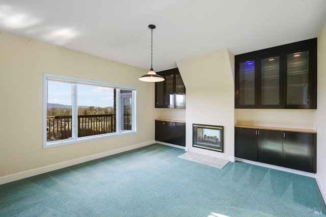 unfurnished living room featuring carpet flooring and baseboards