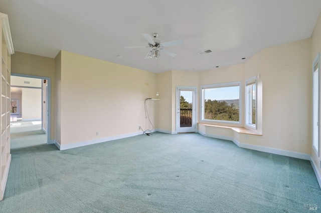 spare room with ceiling fan, carpet, visible vents, and baseboards