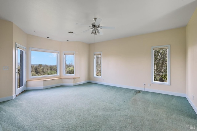 carpeted empty room featuring visible vents, ceiling fan, and baseboards