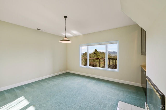 empty room featuring baseboards, visible vents, and dark colored carpet