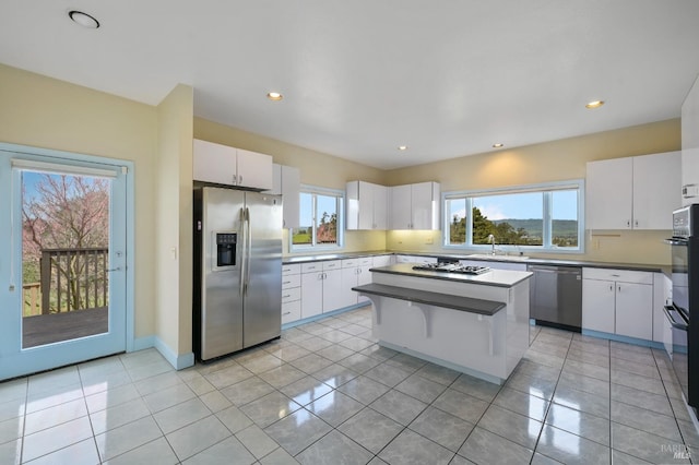 kitchen featuring stainless steel appliances, white cabinets, and light tile patterned floors