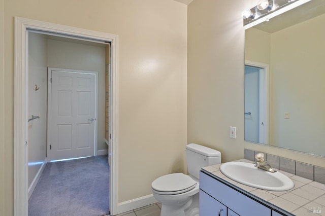 bathroom featuring vanity, toilet, and baseboards