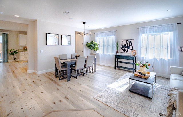 dining area with visible vents, baseboards, recessed lighting, light wood-type flooring, and a chandelier