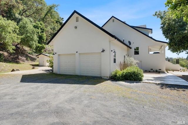 view of property exterior with an attached garage and stucco siding