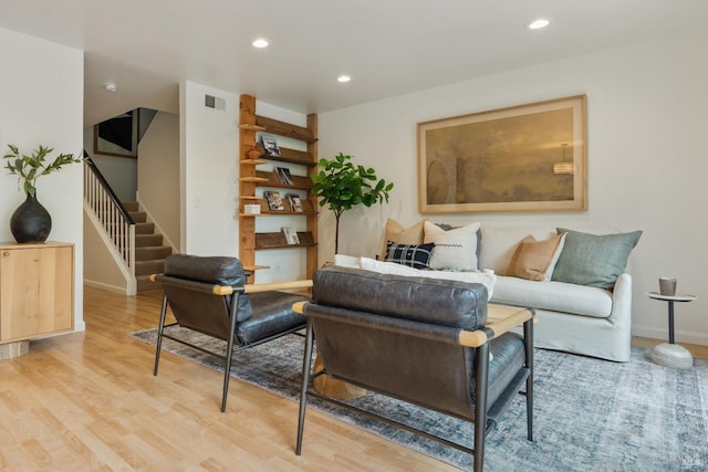 living area featuring recessed lighting, wood finished floors, visible vents, baseboards, and stairway