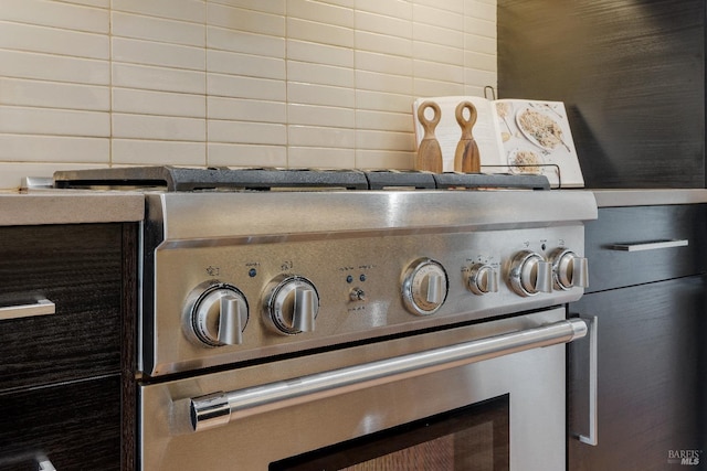 interior details featuring backsplash and stainless steel range with gas stovetop