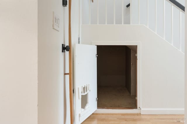 corridor with heating unit and wood finished floors