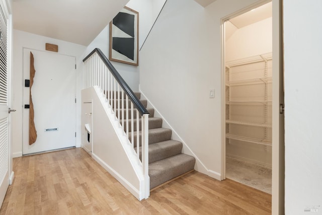 stairway featuring wood finished floors and baseboards