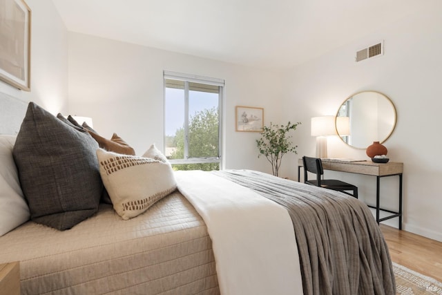 bedroom featuring wood finished floors and visible vents