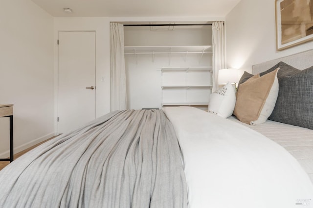 bedroom with a closet, baseboards, and wood finished floors