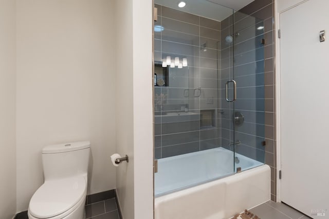 full bathroom featuring toilet, tile patterned flooring, and combined bath / shower with glass door