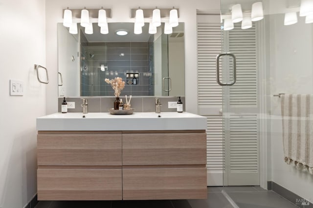 full bath with a sink, double vanity, a shower stall, and tile patterned floors