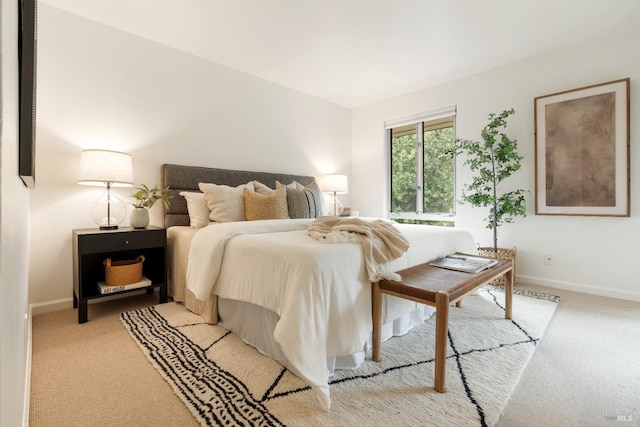 bedroom featuring light carpet and baseboards