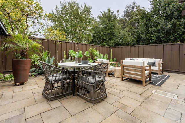 view of patio / terrace with outdoor dining area, a fenced backyard, and an outdoor living space