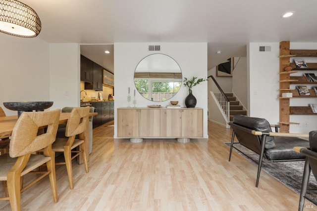 dining area with light wood-type flooring, stairs, visible vents, and recessed lighting