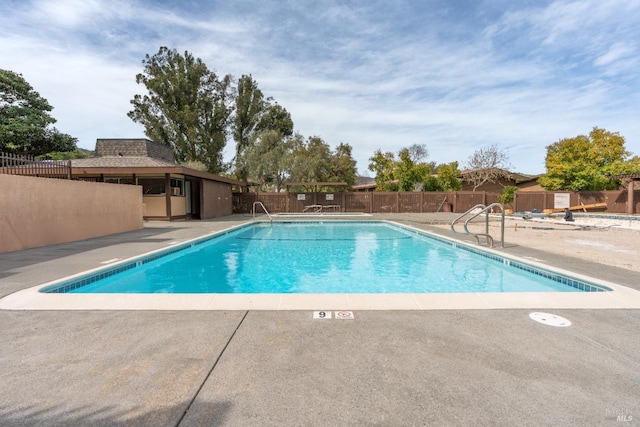 pool featuring fence and a patio