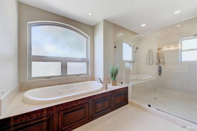 bathroom featuring a stall shower, a bath, recessed lighting, and tile patterned floors