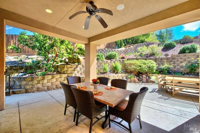 view of patio featuring outdoor dining area, a fenced backyard, and a ceiling fan