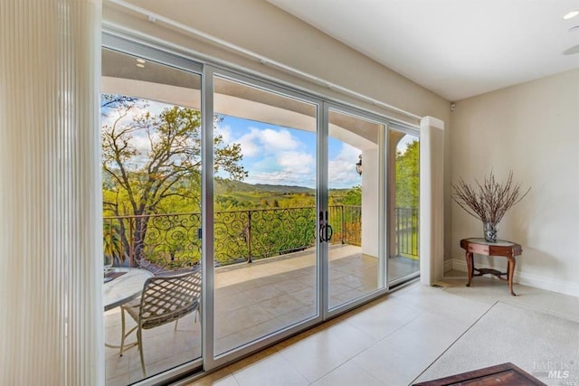 doorway to outside featuring tile patterned floors and baseboards