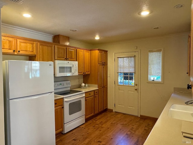 kitchen featuring white appliances, brown cabinetry, light wood-style flooring, light countertops, and crown molding