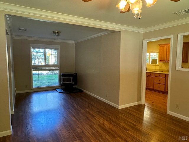 unfurnished room featuring ornamental molding, plenty of natural light, and dark wood finished floors