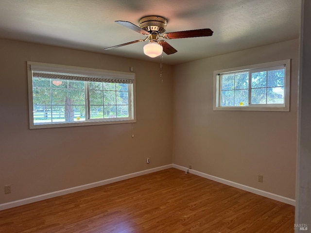 unfurnished room featuring a ceiling fan, baseboards, and wood finished floors