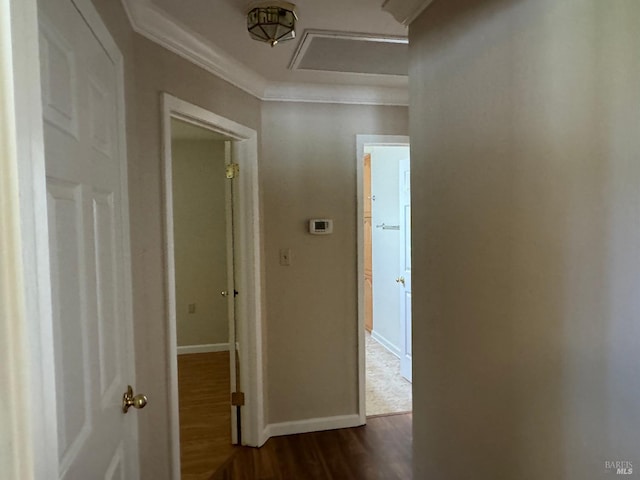 hall with ornamental molding, dark wood-style flooring, attic access, and baseboards