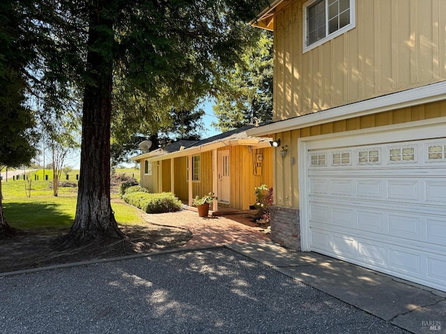 view of property exterior with a garage and driveway