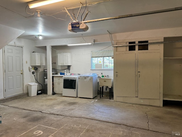 garage with a sink, washer and dryer, and a garage door opener