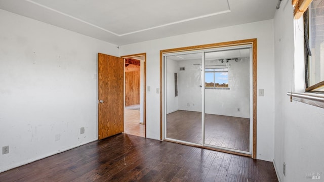 unfurnished bedroom with a closet and hardwood / wood-style floors