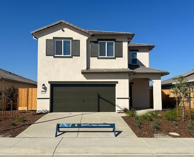 view of front facade featuring fence, a tiled roof, and stucco siding