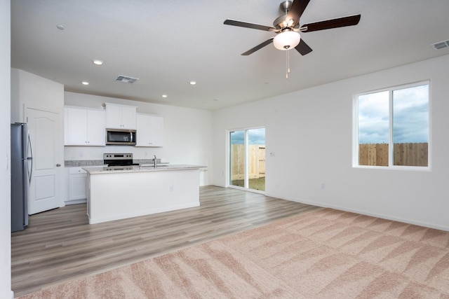 kitchen with recessed lighting, visible vents, appliances with stainless steel finishes, open floor plan, and white cabinets