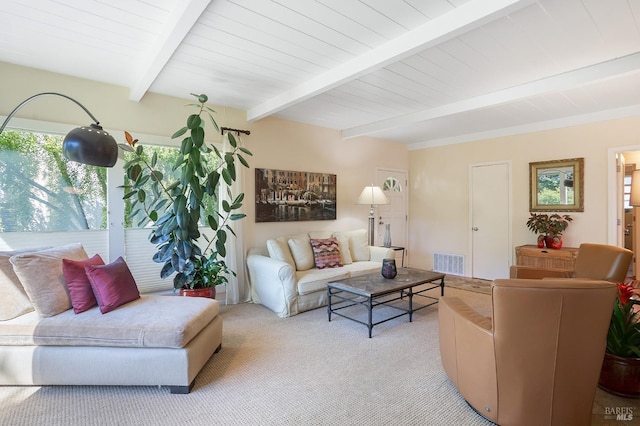 living area with visible vents, beam ceiling, and light colored carpet