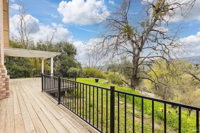 wooden terrace featuring a pergola and a lawn