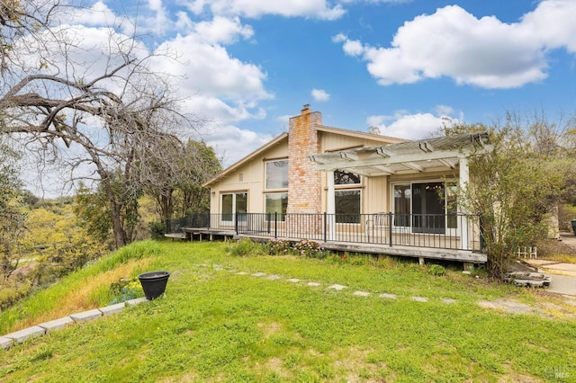 exterior space with a chimney, a deck, and a front yard